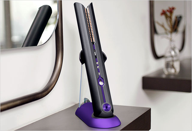 Close up of professional stylist using a cordless Dyson Corrale hair straightener