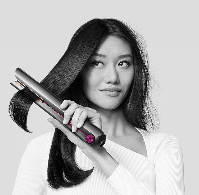 Woman drying her hair with the Dyson supersonic hair dryer